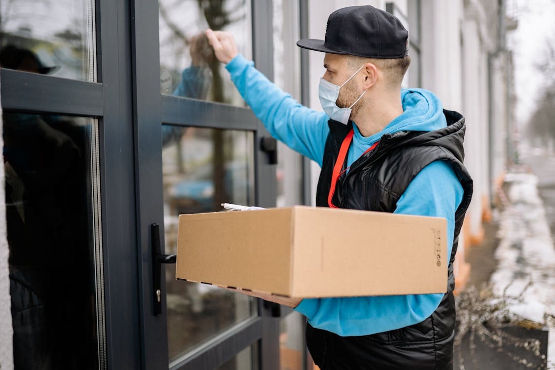 Courier knocking on a residential door with a package