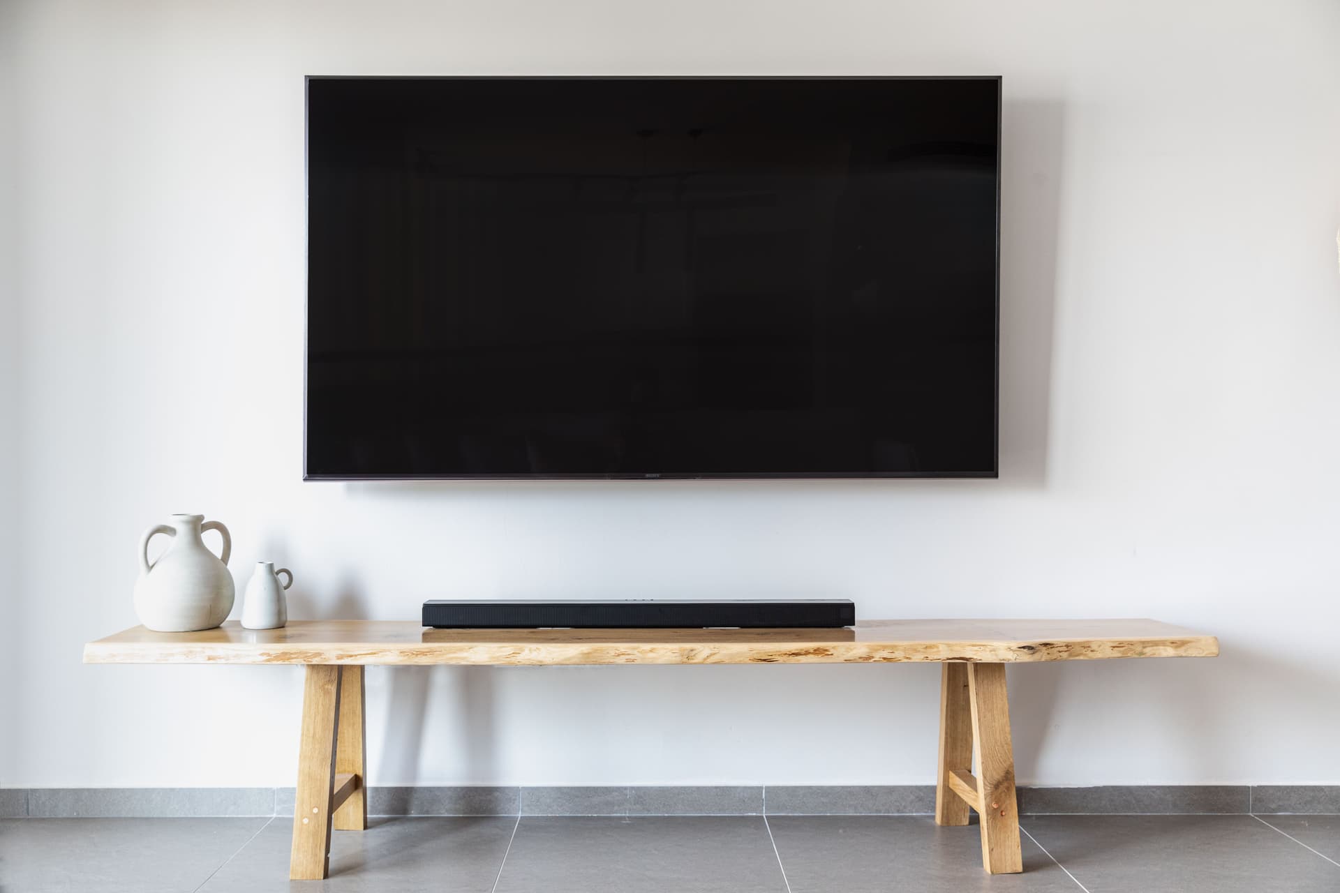 Professional installer mounting a large flat-screen TV on a plasterboard wall
